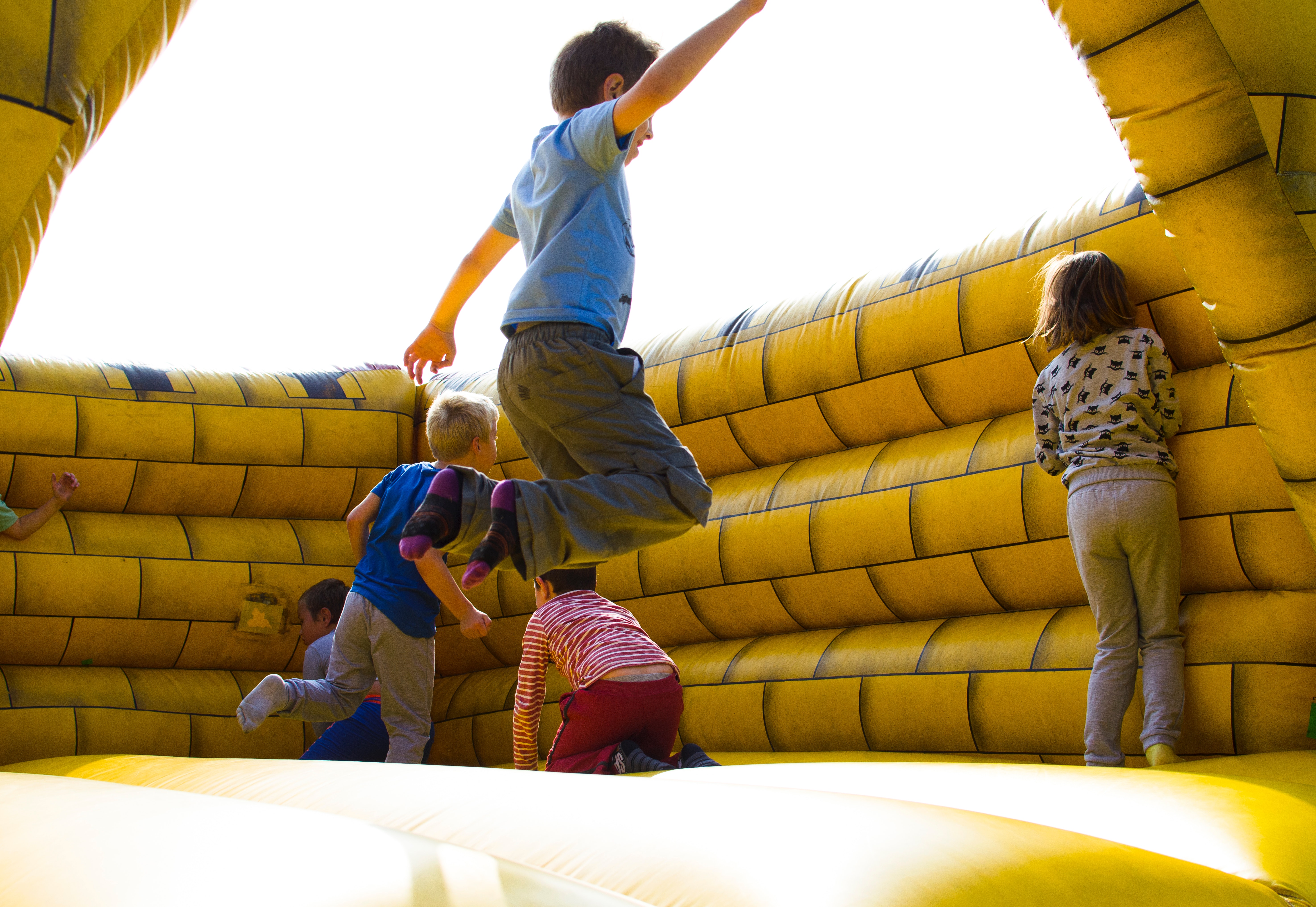 Várias crianças pulando e brincando em um pula pula inflável