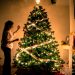 criança colocando uma bola de natal na árvore de Natal