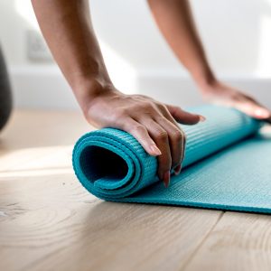 mão enrolando um tapete de yoga