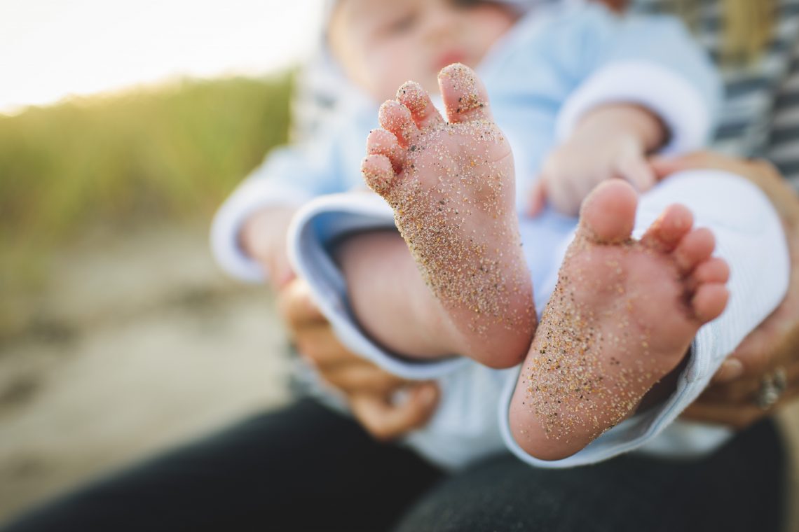 pés de bebê sujos de areia