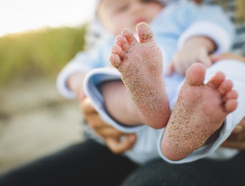 pés de bebê sujos de areia