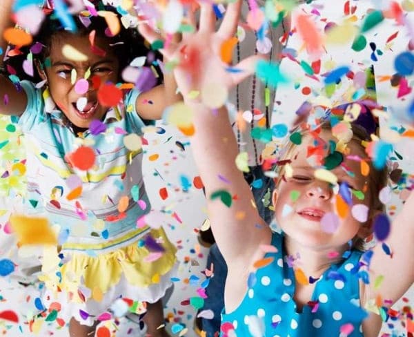 Crianças jogando confete para cima