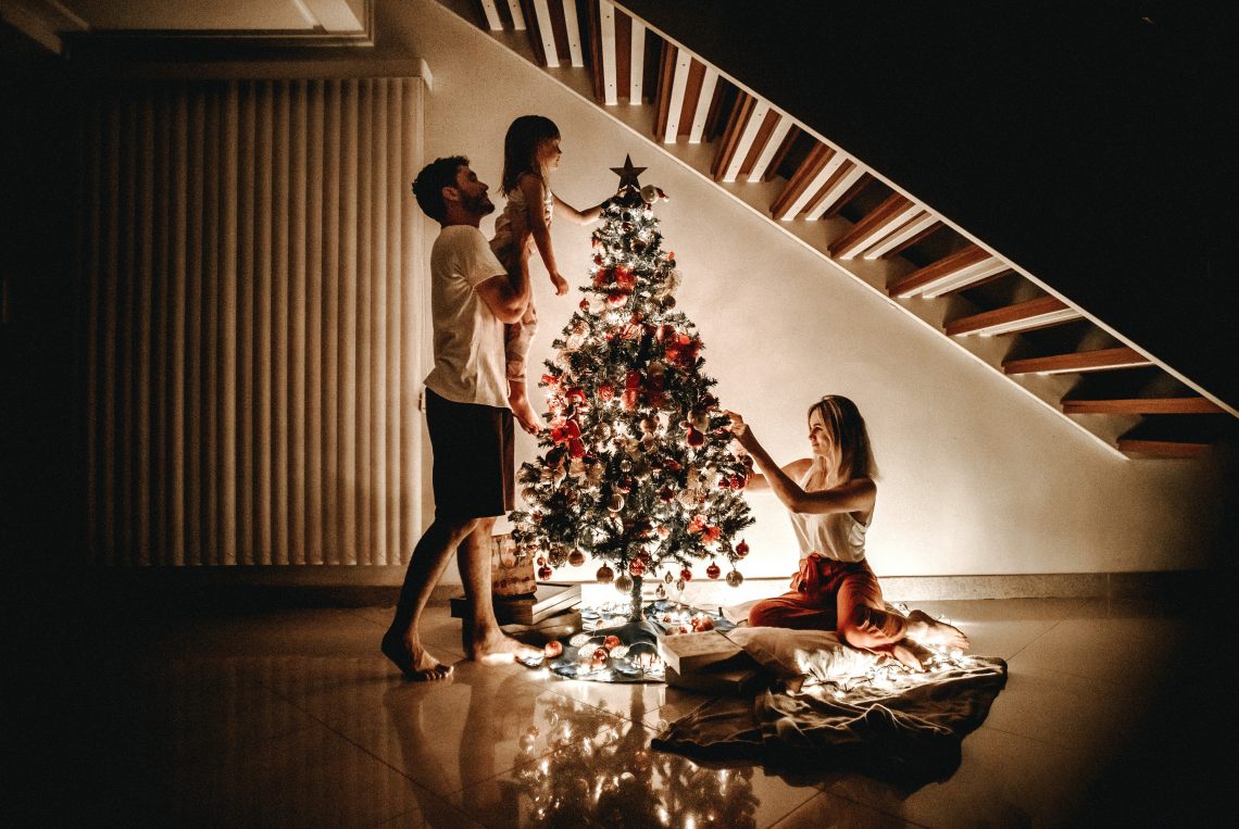 família enfeitando a árvore de Natal
