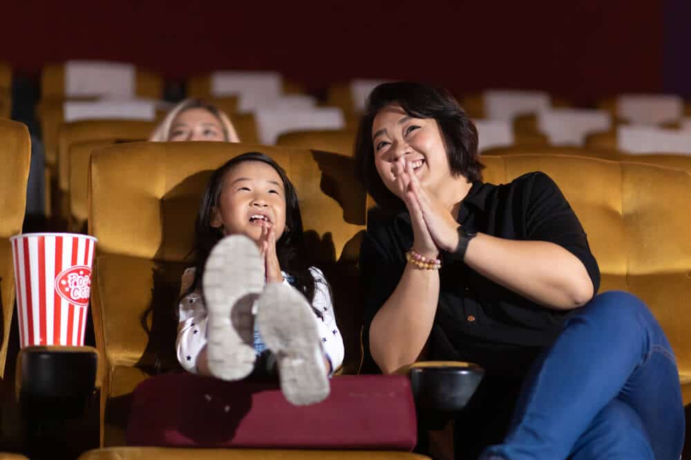 mãe e filha em sala de cinema assistindo a um filme após decidir o que fazer no fim de semana em sp